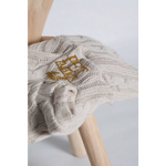 Cream-colored sweterek wełniany dla psa with gold embroidered logo patch that chroni szyję pupila