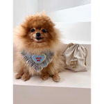 Fluffy tan pomeranian wearing a blue tweed true love coco heart-shaped fringed bib with hug me embroidery