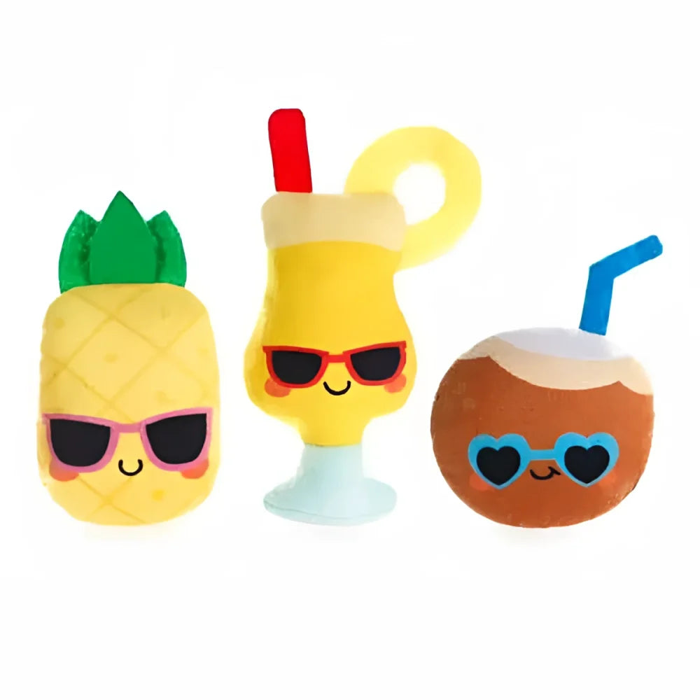 Trzy pluszowe zabawki w tropikalnym stylu: żółty ananas z zieloną czubką i różowymi okularami przeciwsłonecznymi, żółty koktajl w szklance z czerwoną słomką i pomarańczowymi okularami przeciwsłonecznymi z rantem, oraz pomarańczowy kokos z niebieskimi okularami w kształcie serca.