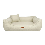 Cream-colored legowisko belluno boucle beige dog bed with plush sherpa material, matching pillow, and brown leather tag