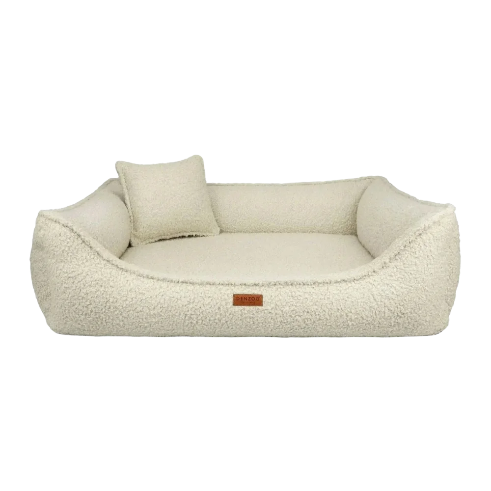 Cream-colored legowisko belluno boucle beige dog bed with plush sherpa material, matching pillow, and brown leather tag