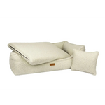Cream-colored plush sherpa pet bed with matching pillow and accent cushion in legowisko belluno boucle beige material