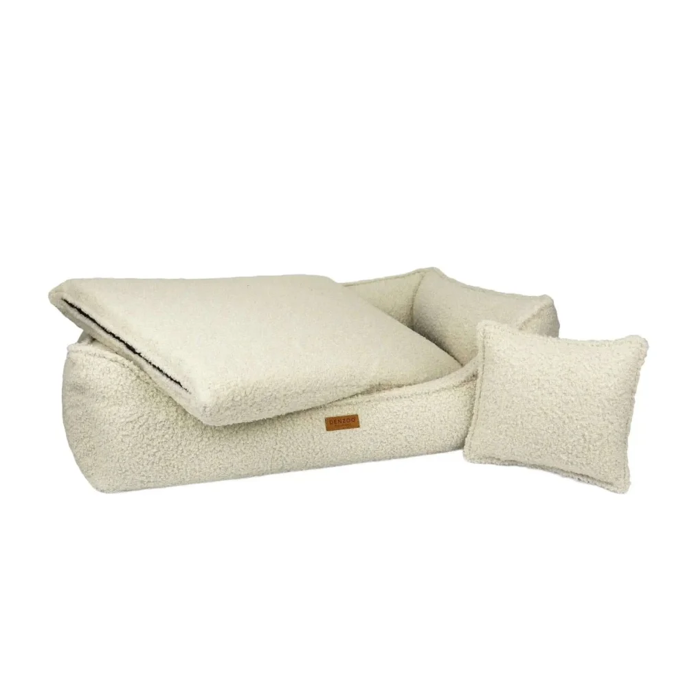 Cream-colored plush sherpa pet bed with matching pillow and accent cushion in legowisko belluno boucle beige material