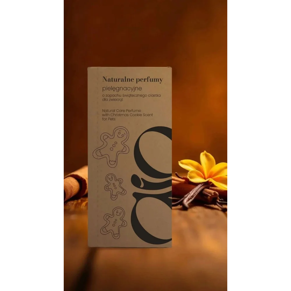Prostokątne beżowe pudełko z czarnym tekstem i ilustracjami pierników, oznaczone ’natural care perfume’ dla zwierząt.