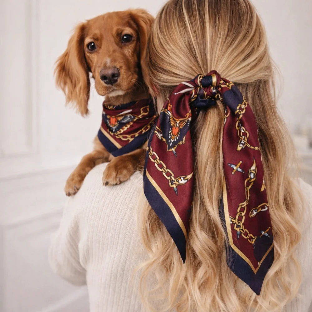 Maroon and navy silk riviera set scarf with gold chain and eagle motifs tied in a bow at the nape for psa and humans