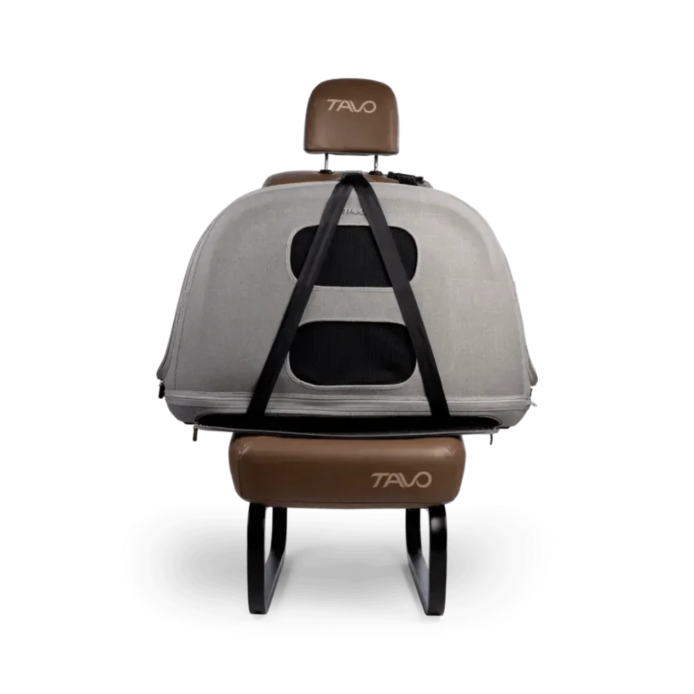 Przenośny fotel recliner marki Tavo z smukłą szarą obudową, brązową, skórzaną w dotyku poduszką pod głowę i podnóżkiem oraz czarnymi regulowanymi pasami.