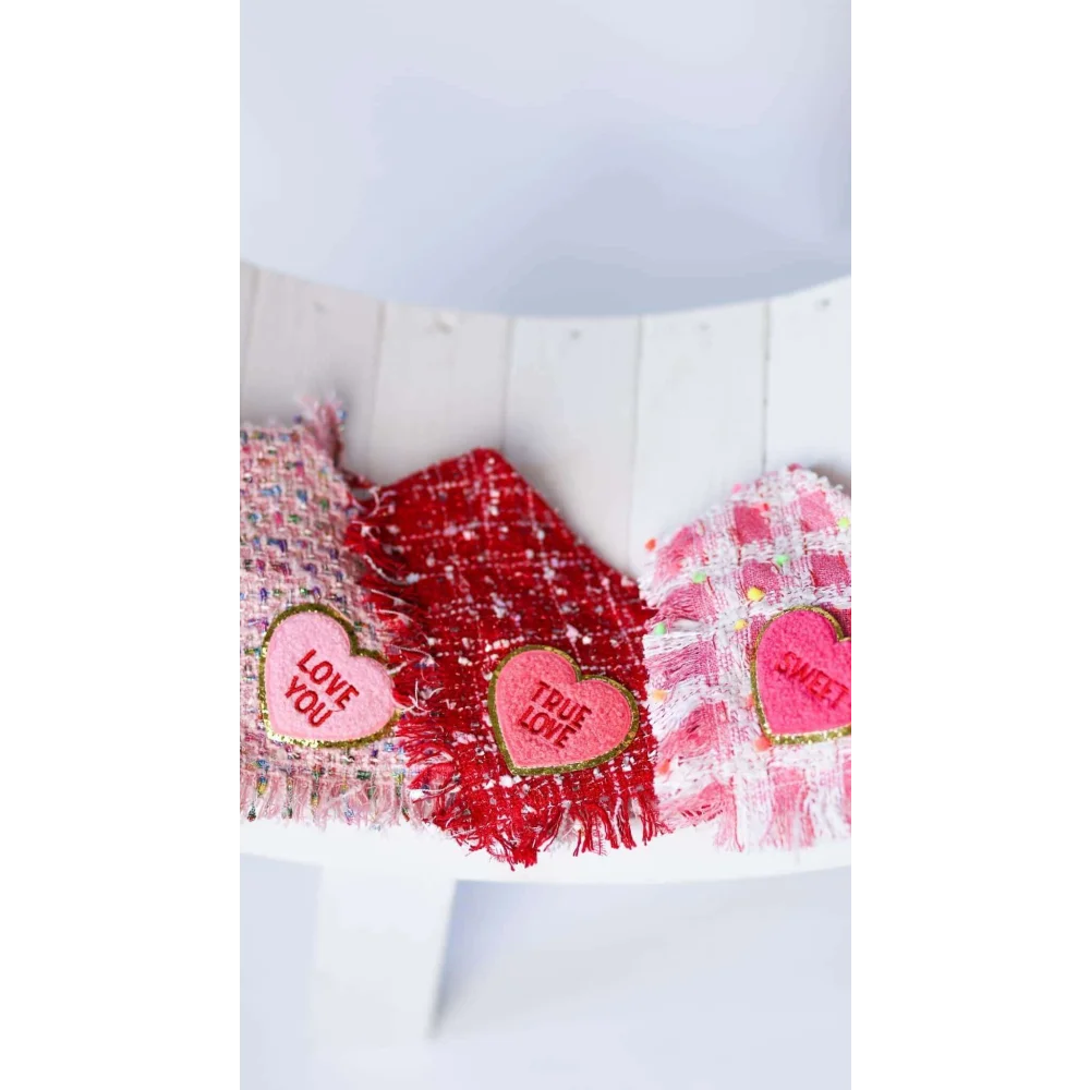 Three heart-shaped fabric patches with embroidered love messages on pink and red tweed backgrounds for chusta true love coco